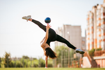 girl in black sport outfit doing doing gymnastics handstand in the splits © Bogdan