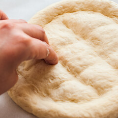 Round dough on a table, preparing ramadan pide.