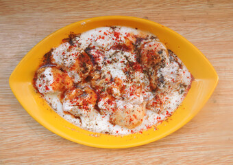 A snack originating from the Indian subcontinent called Dahi vada in local language and popular throughout South Asia.  It is prepared by soaking fried flour balls in thick yogurt. 