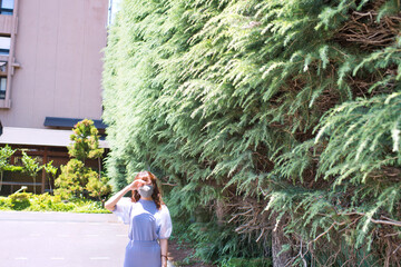 マスク姿の若い女性　夏の屋外