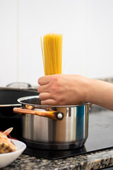Boiling spaghetti in pan on electric stove in the kitchen