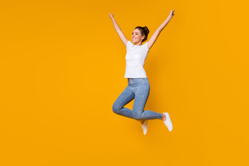 Fototapeta na wymiar Full length body size view of her she nice-looking attractive lovely cheerful cheery girl jumping rising hands up rejoicing isolated over bright vivid shine vibrant yellow color background