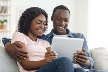 Closeup of smiling african man and woman using digital tablet