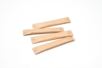 Sugar sticks on a white background. Sugar sticks without logo. Craft paper sugar bags. Sugar bags made of black paper. Mockup for applying a logo.