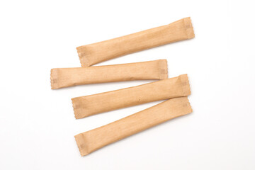Sugar sticks on a white background. Sugar sticks without logo. Craft paper sugar bags. Sugar bags made of black paper. Mockup for applying a logo.