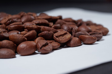 beautiful coffee beans sprinkled on a white table with a black background