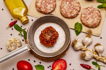 Raw and fried cutlets, fresh vegetables, spices, olive oil. Vintage pan, picnic or barbecue cooking concept
