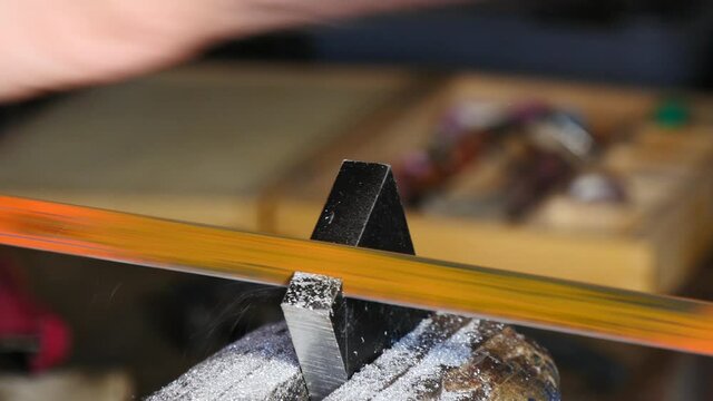 close up of man worker cutting a piece of metal with hacksaw