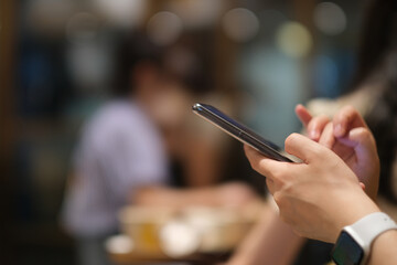 close up woman's hands using smart phone. Colorful bokeh background