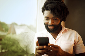 Bearded young african american man looking at his smartphone