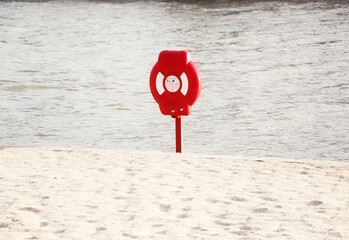 red and white sing on the beach, life preserver on the beach, safe rest 