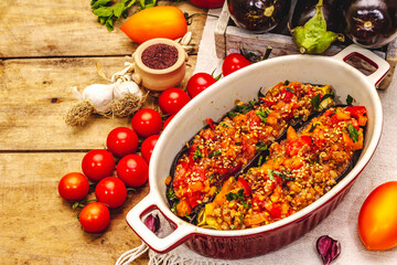 Karniyarik traditional Turkish food from stuffed eggplants with minced meat, tomato, greens and sesame seeds