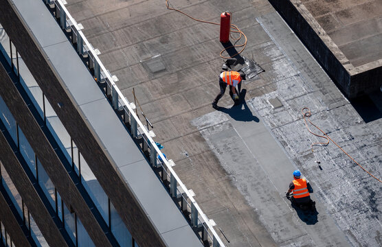 Birds eye view of a roof construction site. Professional bitumen waterproofing on a flat building.
