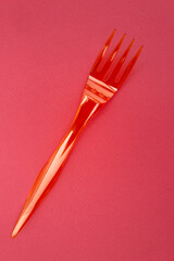 fourchette en plastique rouge sur fond rouge