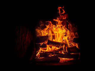 Fire and flame in the dark, with smoke and flames dancing on black background.