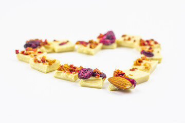 White chocolate with dried berries, fruits and almonds in the shape of a heart.