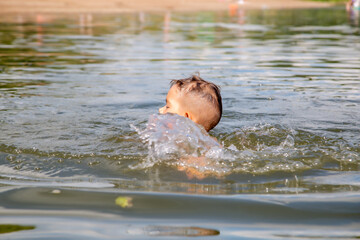 boy swims on the river