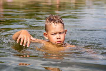 boy swims on the river