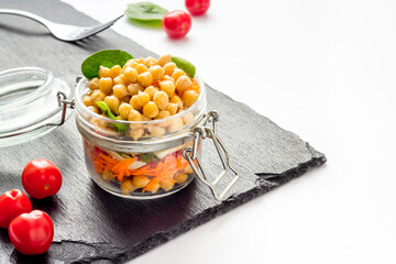 Healthy vegan food. Chickpeas with vegetables in glass jar copy space