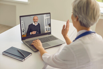 Physician online. Female doctor having online consultation with senior patient at clinic.