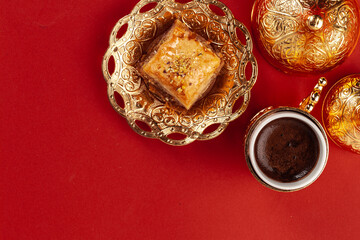 Turkish baklava and coffee in oriental dishware on red background
