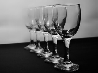 Row of empty wine glasses on table. Black and white concept