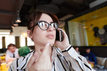 portrait of businesswoman with glasses using mobile phone