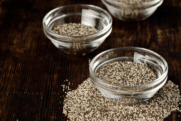 Glass bowl with chia seeds on wooden table