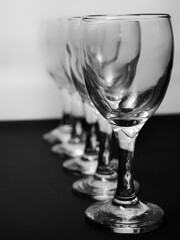 Row of empty wine glasses on table. Black and white concept
