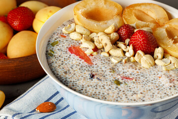 Bowl of chia poudding with pieces of apricots and strawberry