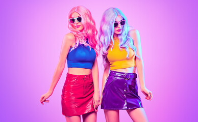 Fashion. Disco party woman have fun dance. Two DJ girl in colorful neon light, sisters. Beautiful...