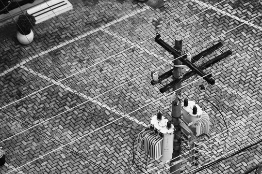 Poste com dois transformadores e cal&ccedil;ada.