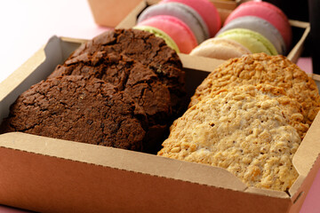 Carton box with oat cookies on pink table