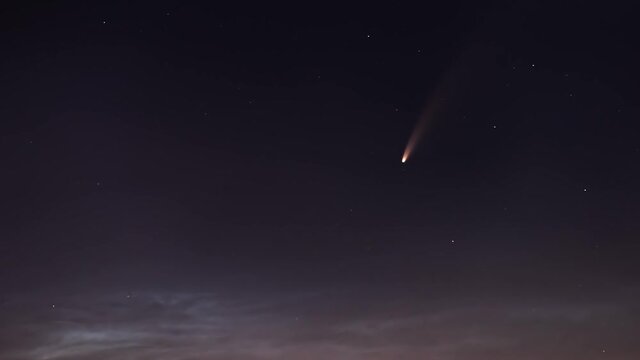 Timelapse of C/2020 F3 (NEOWISE) comet movement against a background of silvery clouds and stars close up