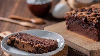 Chocolate flavor Taiwanese traditional sponge cake (Taiwanese castella kasutera) on a wooden tray background table with ingredients, close up.