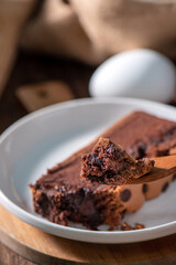 Chocolate flavor Taiwanese traditional sponge cake (Taiwanese castella kasutera) on a wooden tray background table with ingredients, close up.