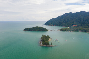 The Danna Bay Aerial view, fly a circle around the lighthouse in front of the Telaga Harbour Marina at Langkawi, Malaysia. Turquoise water in the small lagoon with sailing boats in the sea. 