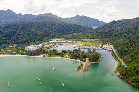 The Danna Bay Aerial view, fly a circle around the lighthouse in front of the Telaga Harbour Marina at Langkawi, Malaysia. Turquoise water in the small lagoon with sailing boats in the sea. 