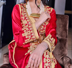 Fototapeta na wymiar Moroccan red caftan with golden painting. The caftan is the uniform in the Maghreb 