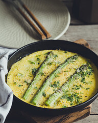 Asparagus with scrambled eggs. Omelet with asparagus  in a frying pan.