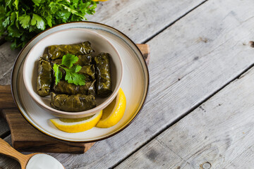Dolma - Stuffed greek wine leaves (dolmades) on a grey wooden background