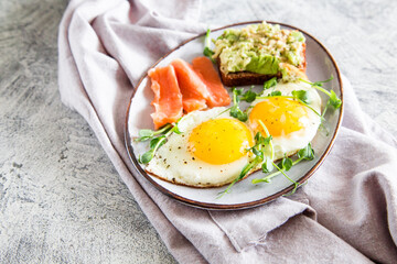 Egg breakfast. Healthy nutritious breakfast with eggs, salmon, avocado sandwich and sprouted pea seeds.