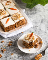 pieces of carrot cake with walnuts with icing cream on a light background. tinting. selective focus