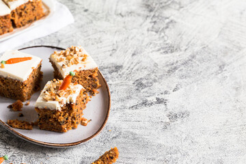 pieces of carrot cake with walnuts with icing cream on a light background. tinting. selective focus