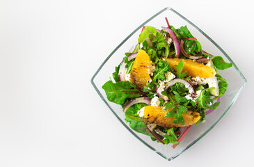 Salad with oranges, feta and arugula isolated on white background