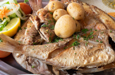tray with grilled fish, baked potatoes and mixed salad