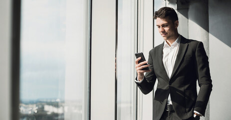 Young man professional using smart phone in office. Businessman working. Communication, connection, business, people, technology concept