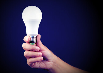 Led energy-saving light bulb in the hand of a person. The concept of modern economical lighting.