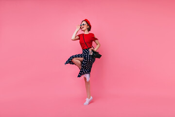 Full-length portrait of appealing french girl in black skirt. Stylish young woman in sunglasses and...