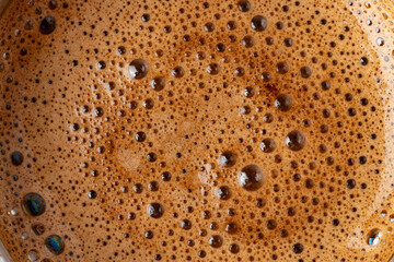 Brown coffee foam with bubles top view